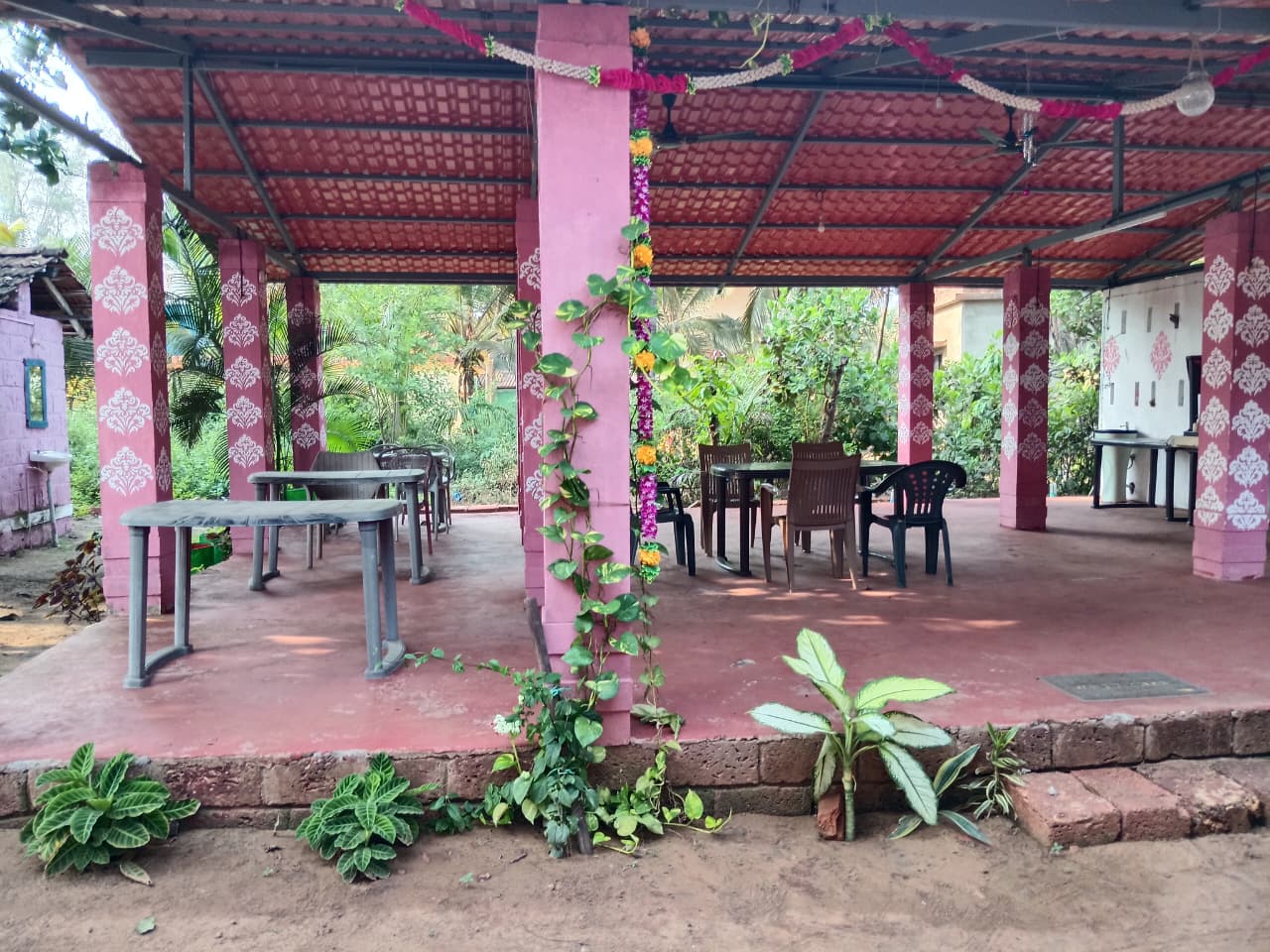 Red resort cottages under palm trees at The Red Stones Resort